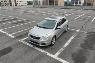 Vue aérienne d'un parking extérieur avec des places standard délimitées par des lignes blanches et une voiture garée